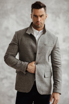 Portrait of handsome man in gray stylish jacket with looking at camera