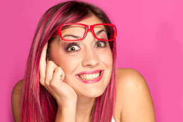 a happy woman with a pink hair and glasses on pink background