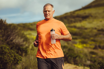 Fototapeta premium Senior man in fitness clothes running outdoors