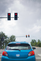 car driving stopped on crossroad with red traffic light