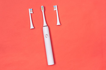 Smart electric toothbrush. Controlled by the application on the smartphone. Modern technology for health. Healthy teeth. Dentistry. Medical robot. Pink coral background
