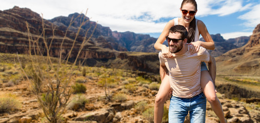 travel, tourism and people concept - happy couple having fun in summer over grand canyon national...