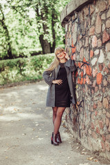 Happy cheerful portrait of young caucasian blondie woman with long hair walking outdoors in park