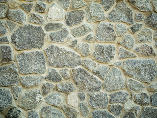 Close up view on grey stone wall surface. Detail of rock wall. Abstract background. Stone wall texture, closeup. An old grey blocks pattern