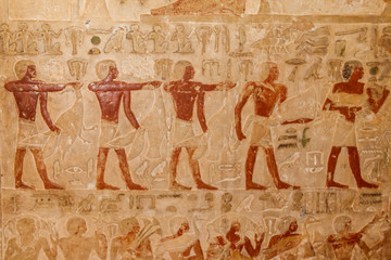 Ancient egyptian paintings and hieroglyphs carved on the stone wall