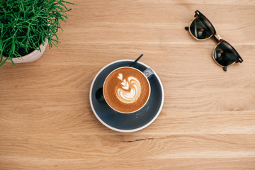 Cappuccino and sunglasses on table - 247758906