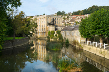 Obraz premium Picturesque homes climb the hill above the River Avon in autumn sunshine, Bradford on Avon, Wiltshire, UK