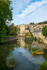 Obraz premium Picturesque homes climb the hill above the River Avon in autumn sunshine, Bradford on Avon, Wiltshire, UK
