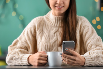 Fototapeta premium Young woman with mobile phone using wifi in cafe