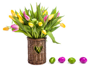 Easter. Easter colored eggs. Flowers Tulips. A bouquet of colorful tulips in a wicker vase. Congratulations on Easter. Isolate on white background