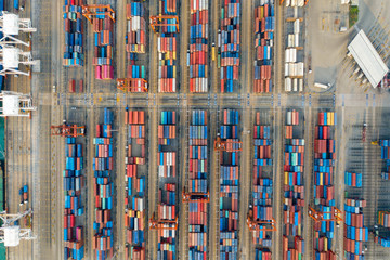 Aerial view. Container ship in pier with crane bridge carries out export and import business in the sea.