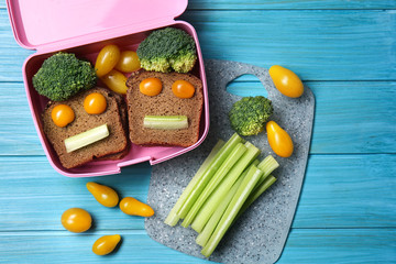 Lunch box with tasty creative food for kid on table