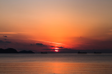 view of the orange sun falling over the sea and the beautiful sky