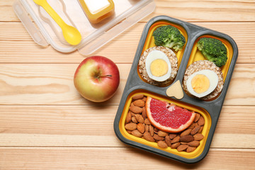 Lunch box with tasty creative food for kid on wooden table