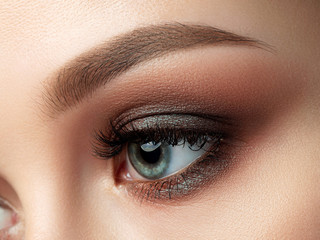Close up of beautiful woman eye with multicolored smokey eyes makeup. Studio shot