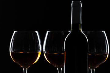  wine bottle and wine glass in a black background