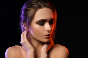 Portrait of beautiful young woman on dark background