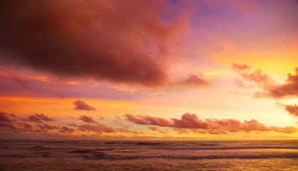 Obraz premium zachód słońca na plaży z niebem pełnym chmury