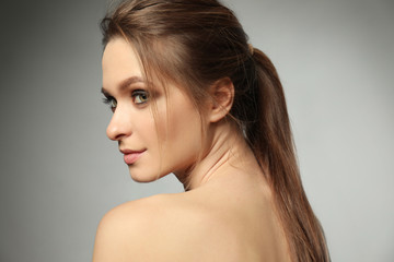 Naklejka premium Portrait of beautiful young woman on grey background