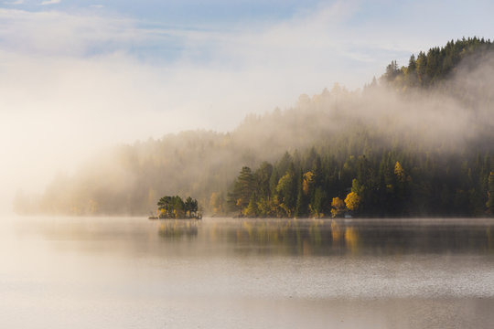 Foggy autumnal morning by the lake. Natural sunrise light. Trondheim area in Norway. - Powered by Adobe