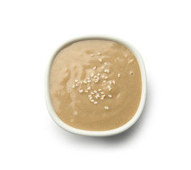Bowl of tasty tahini on white background