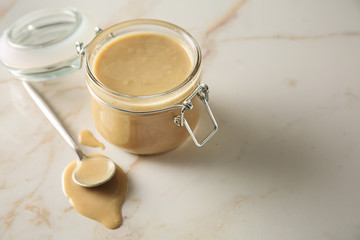 Jar of tasty tahini on light table
