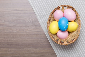 Easter eggs in the basket on wooden background