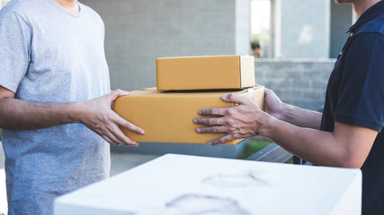 Delivery mail man giving parcel box to recipient, Young owner accepting of cardboard boxes package...