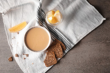 Bowl of tasty tahini on grey table