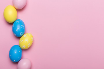 Colorfull easter eggs in nest on pastel color background with space. Concept