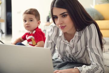 Young mother with her son working at home
