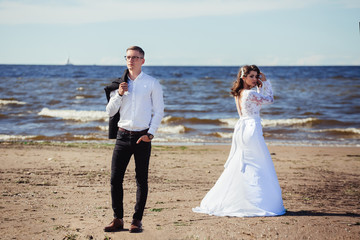 Fototapeta na wymiar Happy young romantic cheerful loving wedding couple walking on the beach of sea. Happiness, couple, love concept
