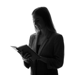 Silhouette of beautiful businesswoman with book on white background
