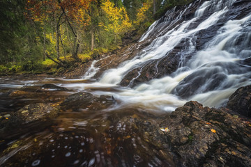 Waterfalls in boreal autumnal forest in Norway.