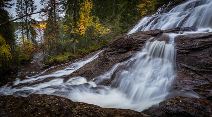 Waterfalls in boreal autumnal forest in Norway.