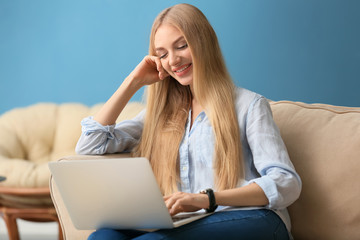 Beautiful young woman using laptop at home