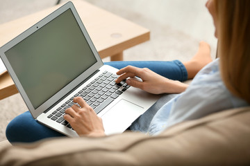 Beautiful young woman using laptop at home