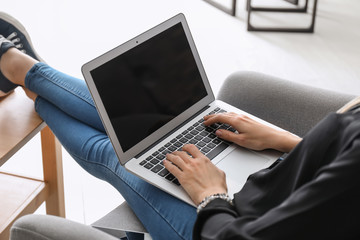 Beautiful young woman using laptop at home