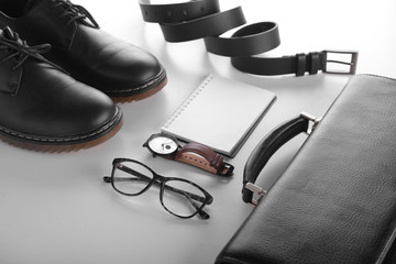 Stylish men's accessories with notebook on white background