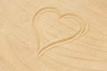 Fototapeta na wymiar valentine's day, love and summer holidays concept - picture of heart in sand on beach