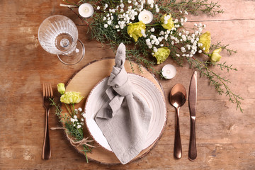Beautiful festive table setting with floral decor on wooden background