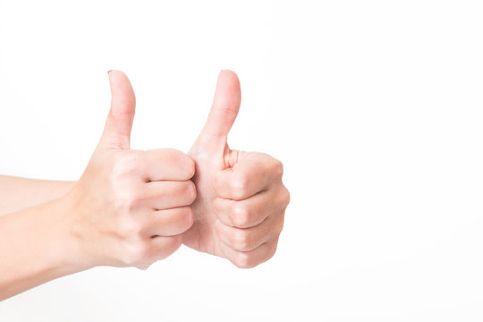 Closeup view of 2 female hands making like gesture. Woman shows thumbs up as sign of success or approval isolated on white background. Horizontal color photography.