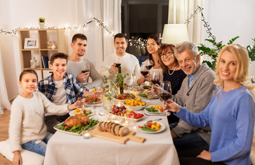 celebration, holidays and people concept - happy family having dinner party, drinking red wine and toasting at home