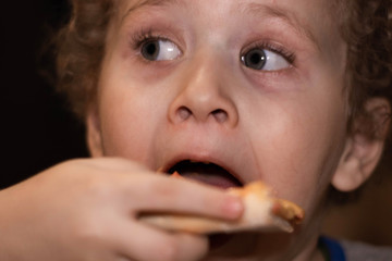 Little boy eats pizza. Portrait close-up