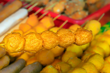 Traditional Asian food on wooden skewers, baked on the grill - satay on the tables of street trading. Close-up