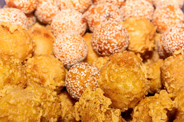 Traditional Asian freshly fried puff pastries in a street vending tray. Close-up
