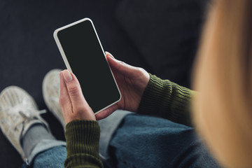 cropped view of woman holding smartphone with blank screen