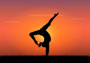 Silhouette of woman doing yoga at sunset