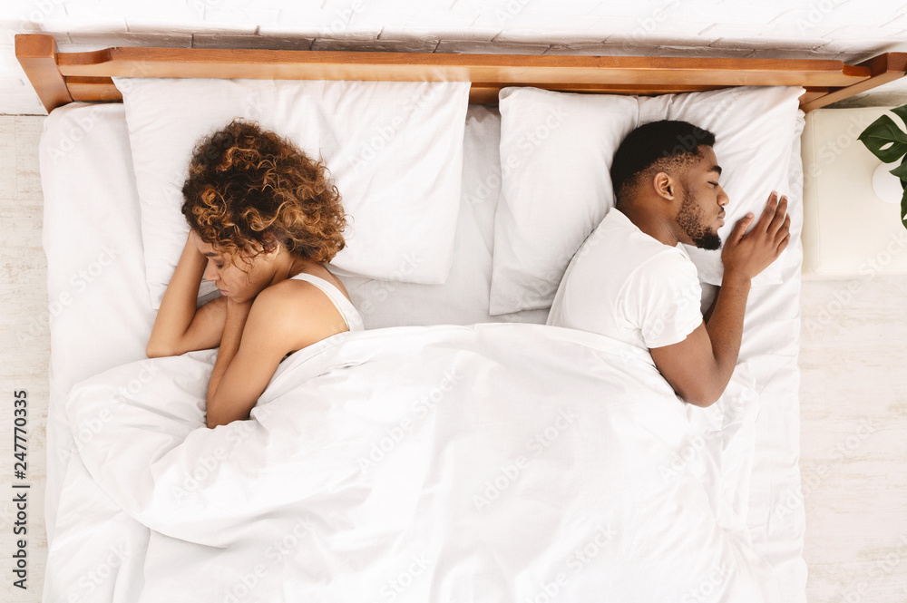 Wall mural upset couple sleeping separately on their bed