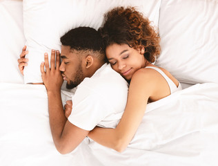 Loving couple sleeping in bed and hugging